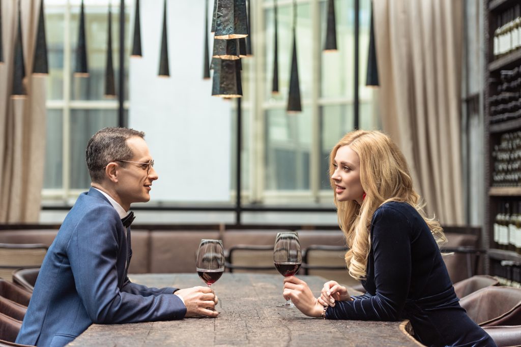 Couple attablé au restaurant avec un verre de vin rouge